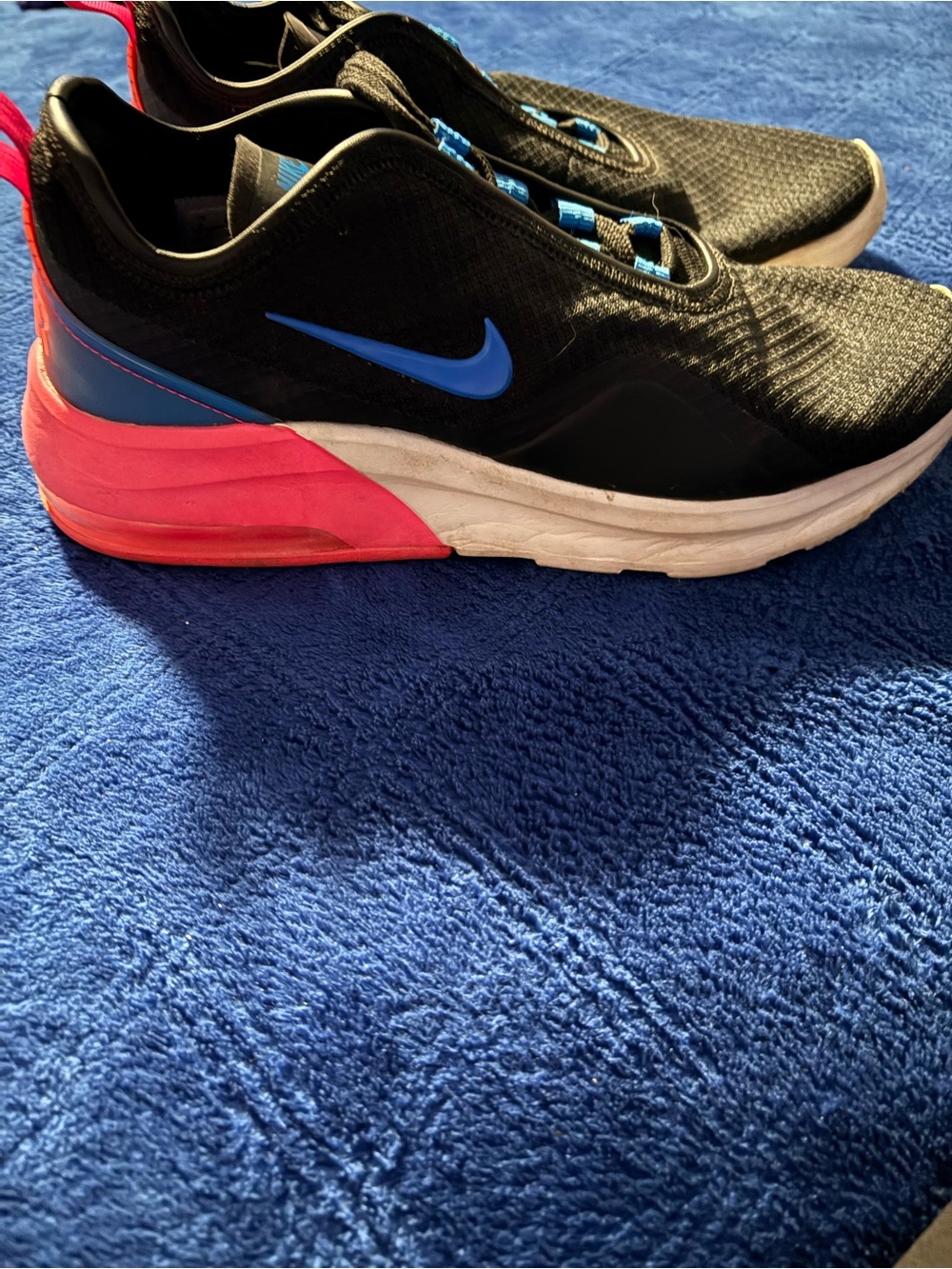 Nike Air Max Motion 2 sneakers in blac, with a vibrant pink heel & blue swoosh